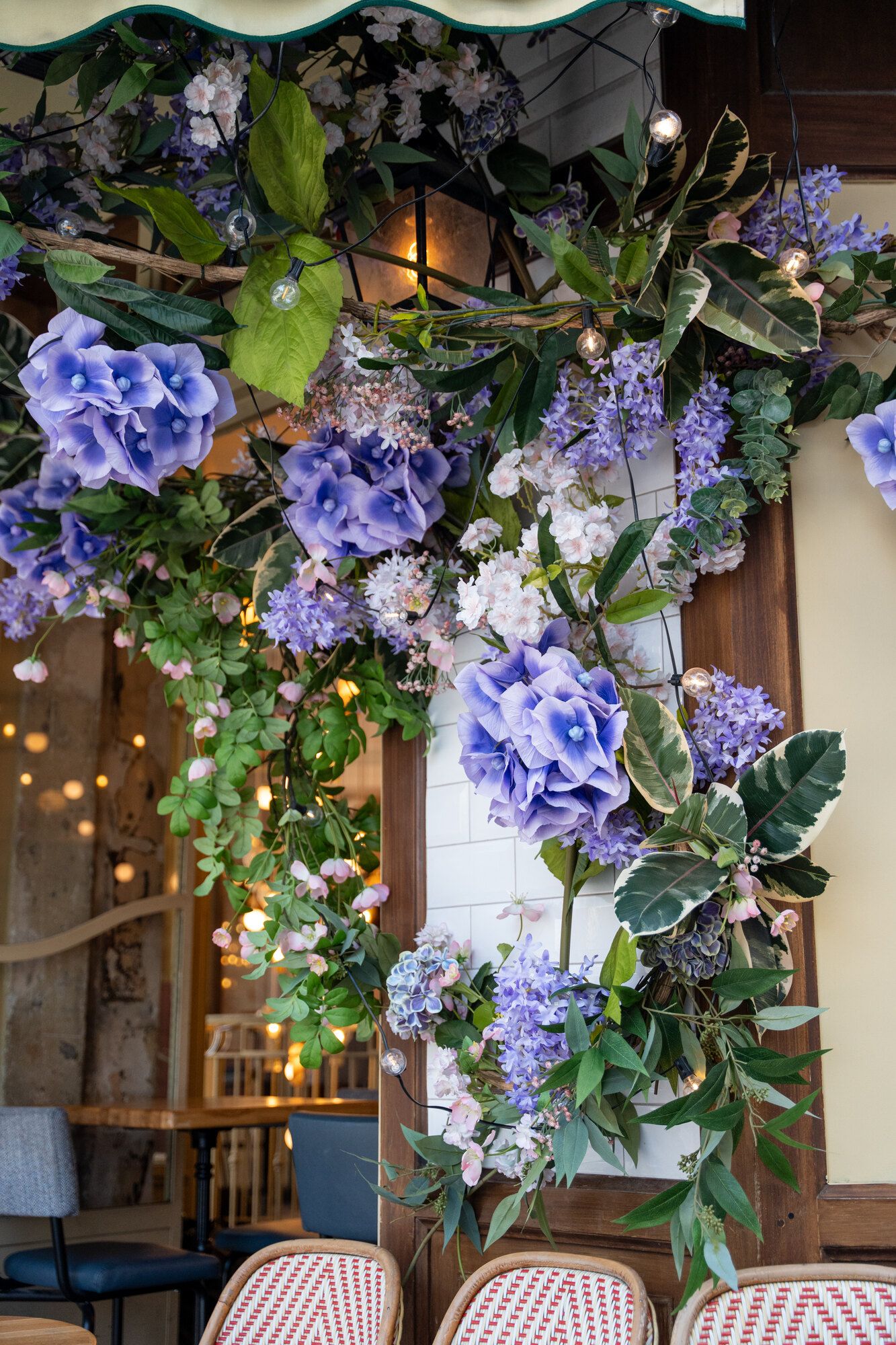 Façade de la brasserie Papilla habillée d'hortensias mauves et de feuillages en fleurs de soie