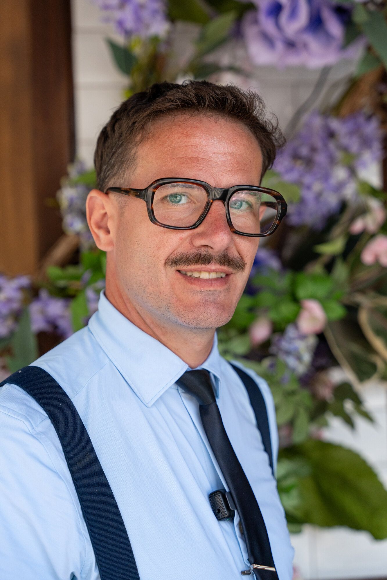 Portrait de Sébastien Chol, décorateur floral scénographe, devant une façade fleurie